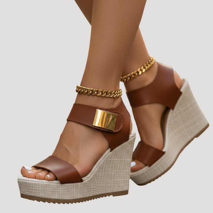 Cognac platform wedge sandals featuring gold hardware and chunky ankle chain