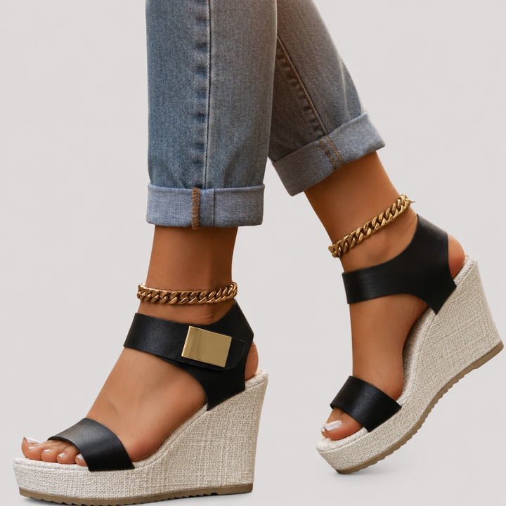 Black platform wedge sandals paired with cuffed jeans and gold anklet
