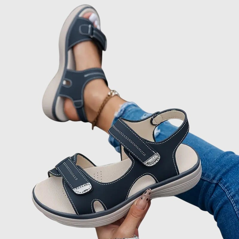 Navy sandals shown mid-step highlighting adjustable strap closures