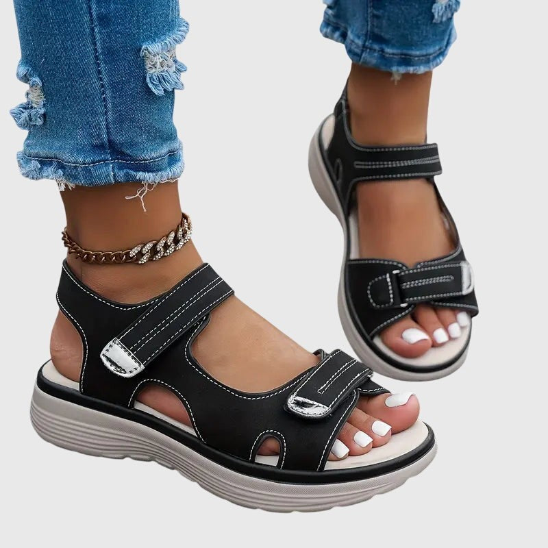 Black orthopedic sandals with contrast stitching and ankle strap design