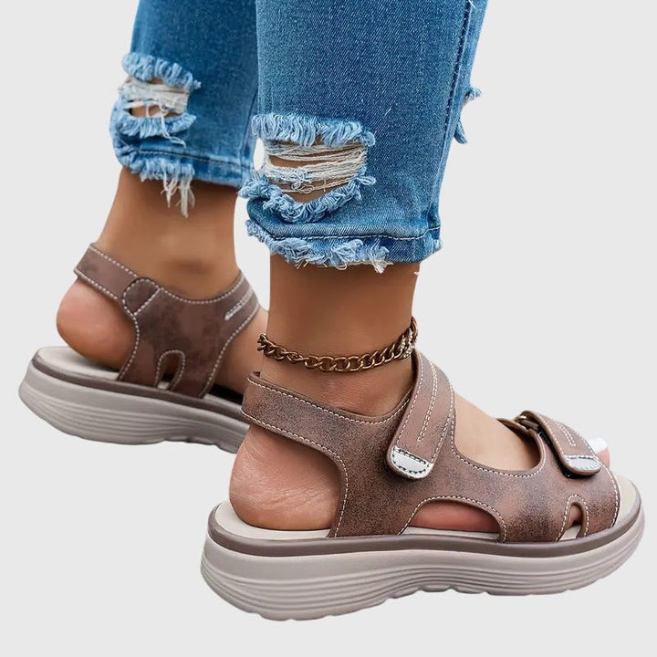 Brown wedge sandals showing side profile with cutout ankle strap