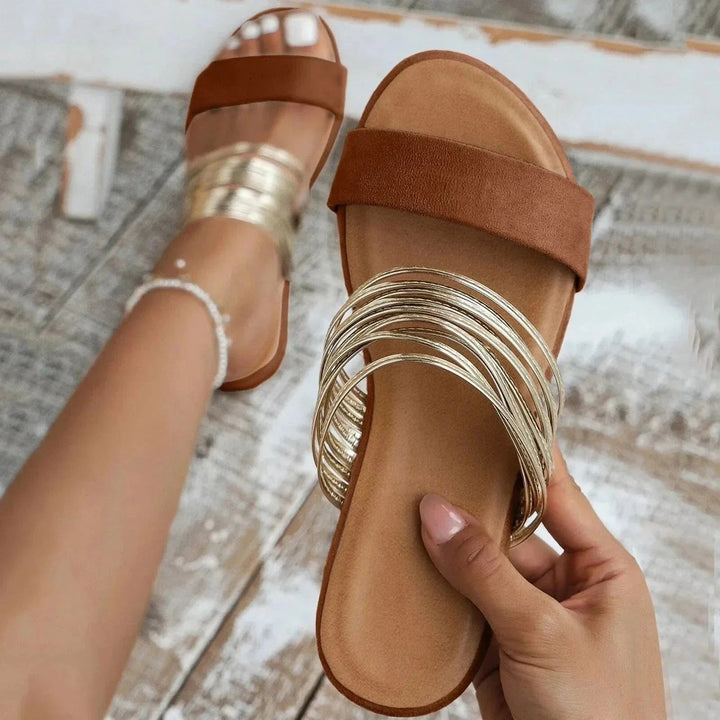 Tan suede slide sandal with strappy gold metallic toe detail