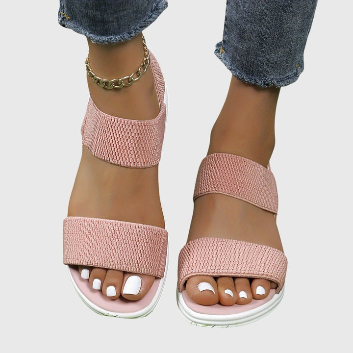 Blush pink double-strap slide sandals with white platform sole, open toe