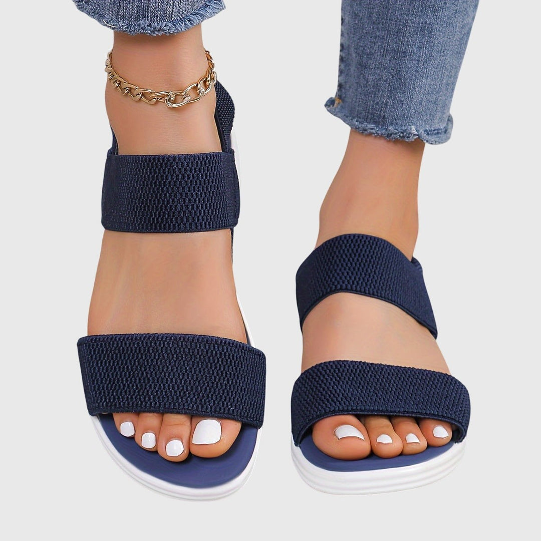 Navy blue woven strap sandals with white wedge sole, ankle wrap detail