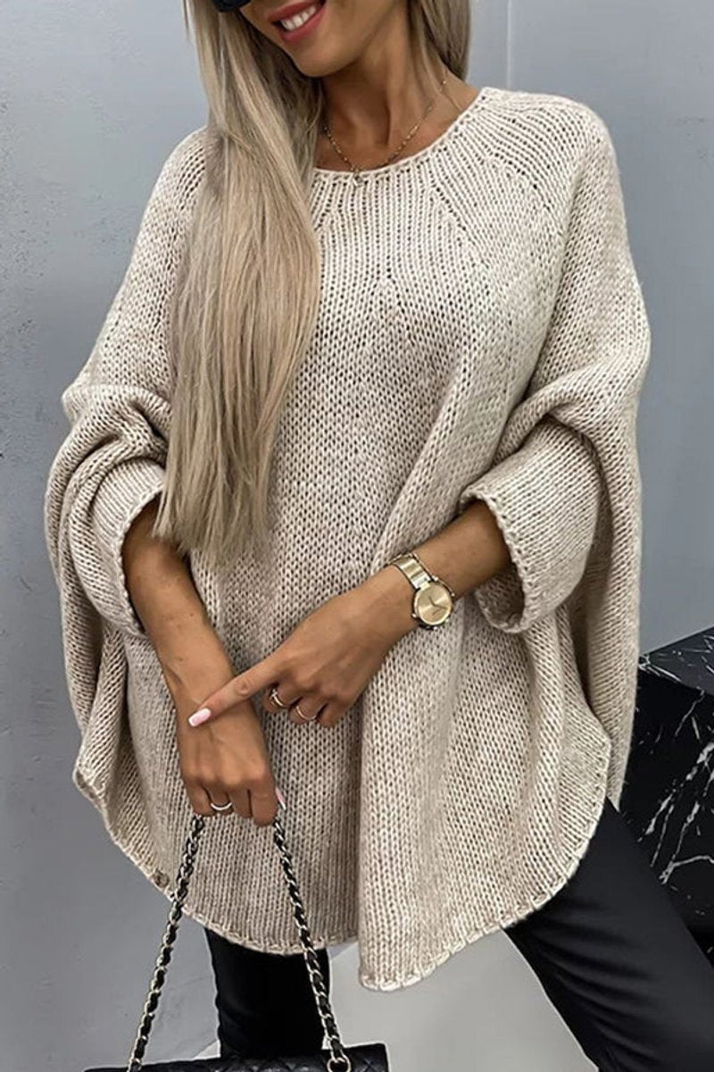 Beige oversized knit sweater with batwing sleeves and crewneck styled with leather leggings