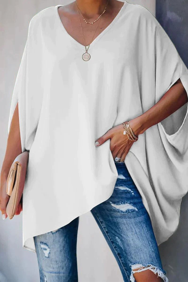 White oversized tunic top featuring V-neck design and flowing batwing sleeves