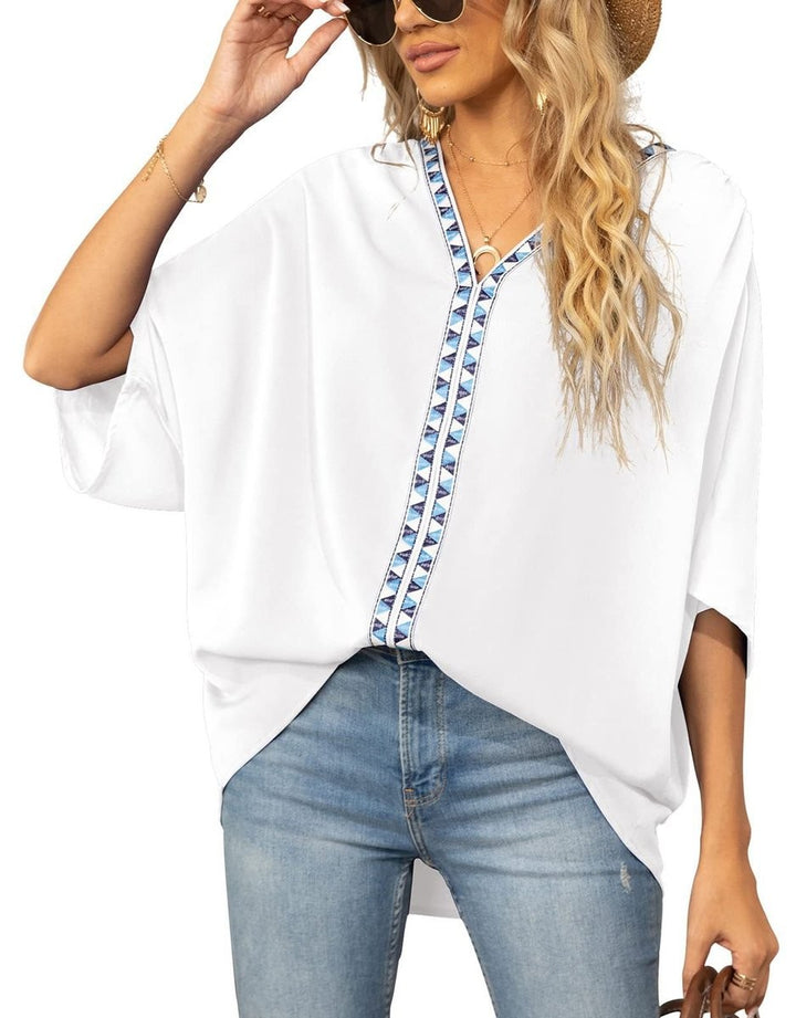 White batwing sleeve blouse with blue and white geometric neckline trim