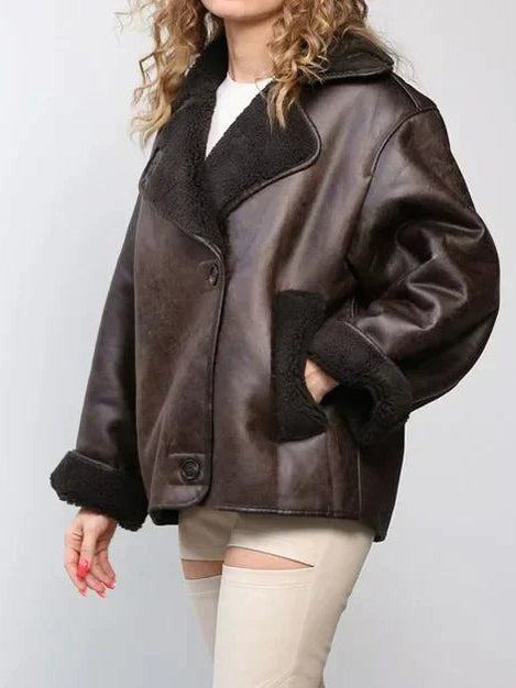 Brown oversized shearling-lined leather jacket with contrast fur collar, worn side-on