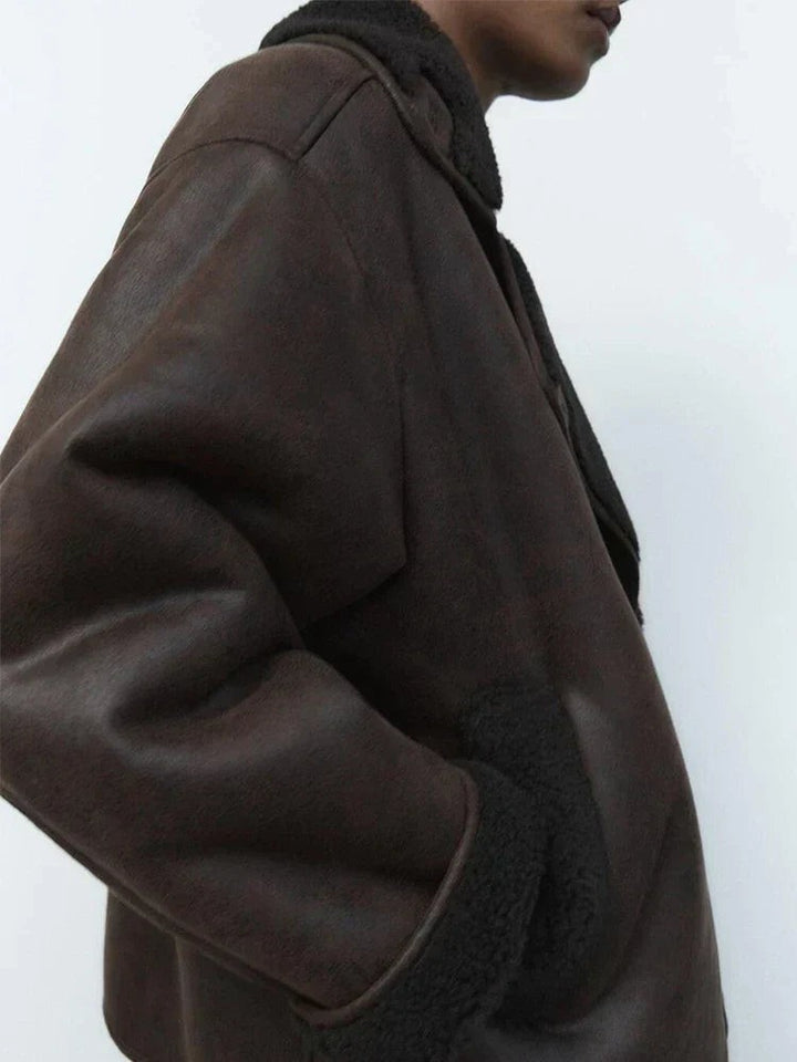 Close-up of brown leather jacket sleeve with fleece-lined pocket detail