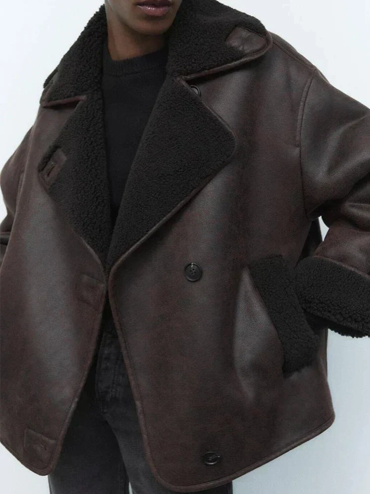 Brown leather jacket with black shearling collar and button fastening, close-up view