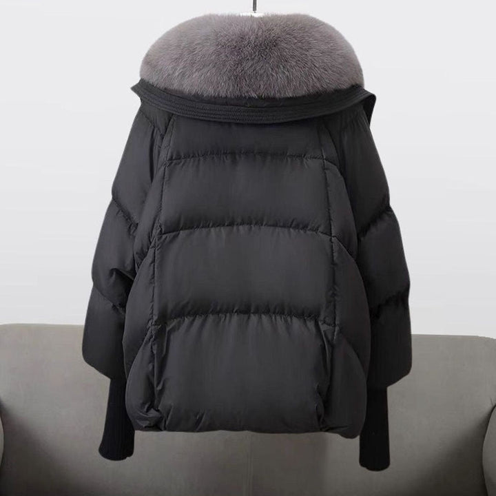 Back view of black puffer jacket showing quilted panels and fur-trimmed hood