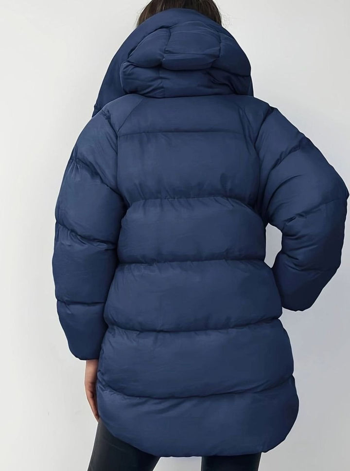 Navy blue oversized puffer coat with hood, back view showing quilted texture