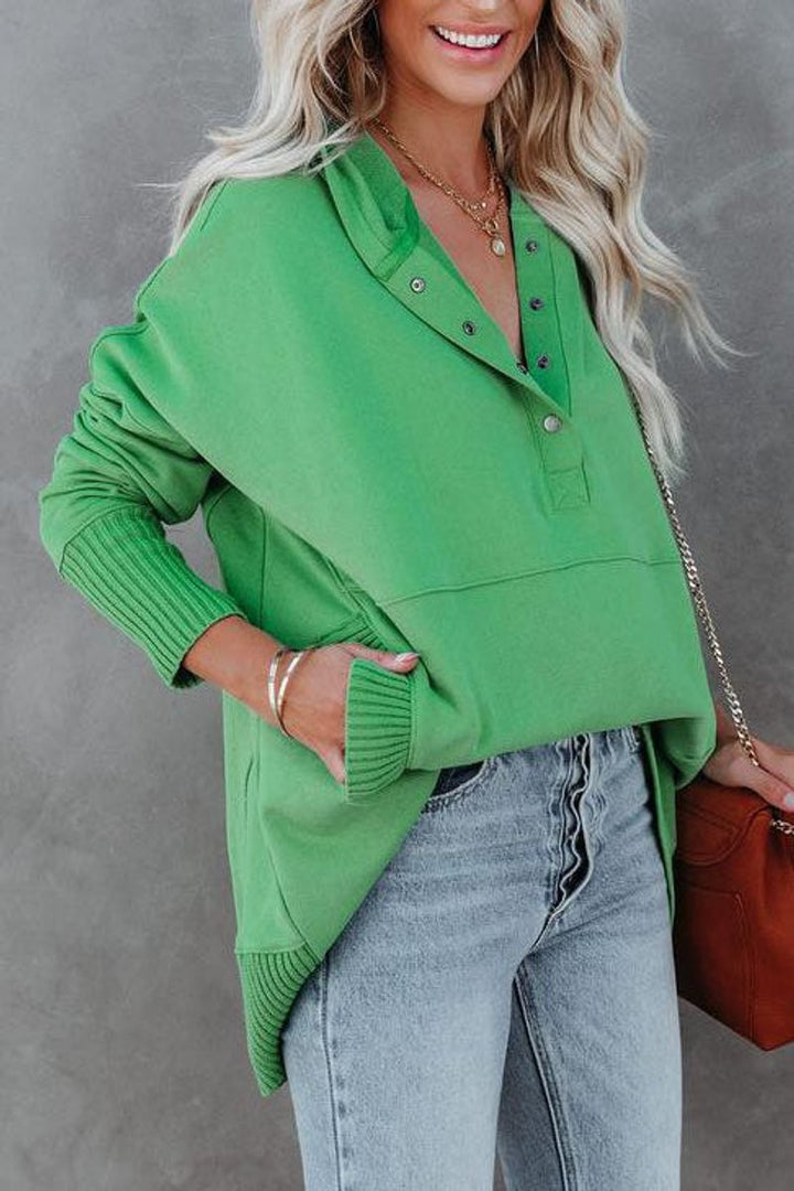 green oversized hooded sweatshirt with snap-button placket and ribbed cuffs