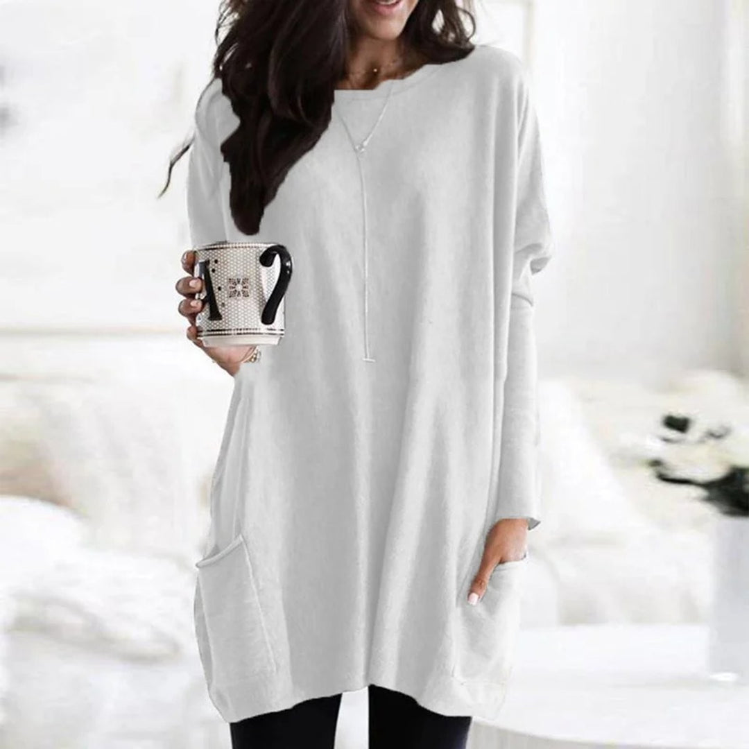 White long-sleeve tunic top with relaxed fit and front patch pocket
