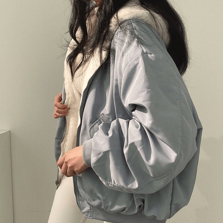 Side view of slate-blue bomber jacket with cream fleece hood lining
