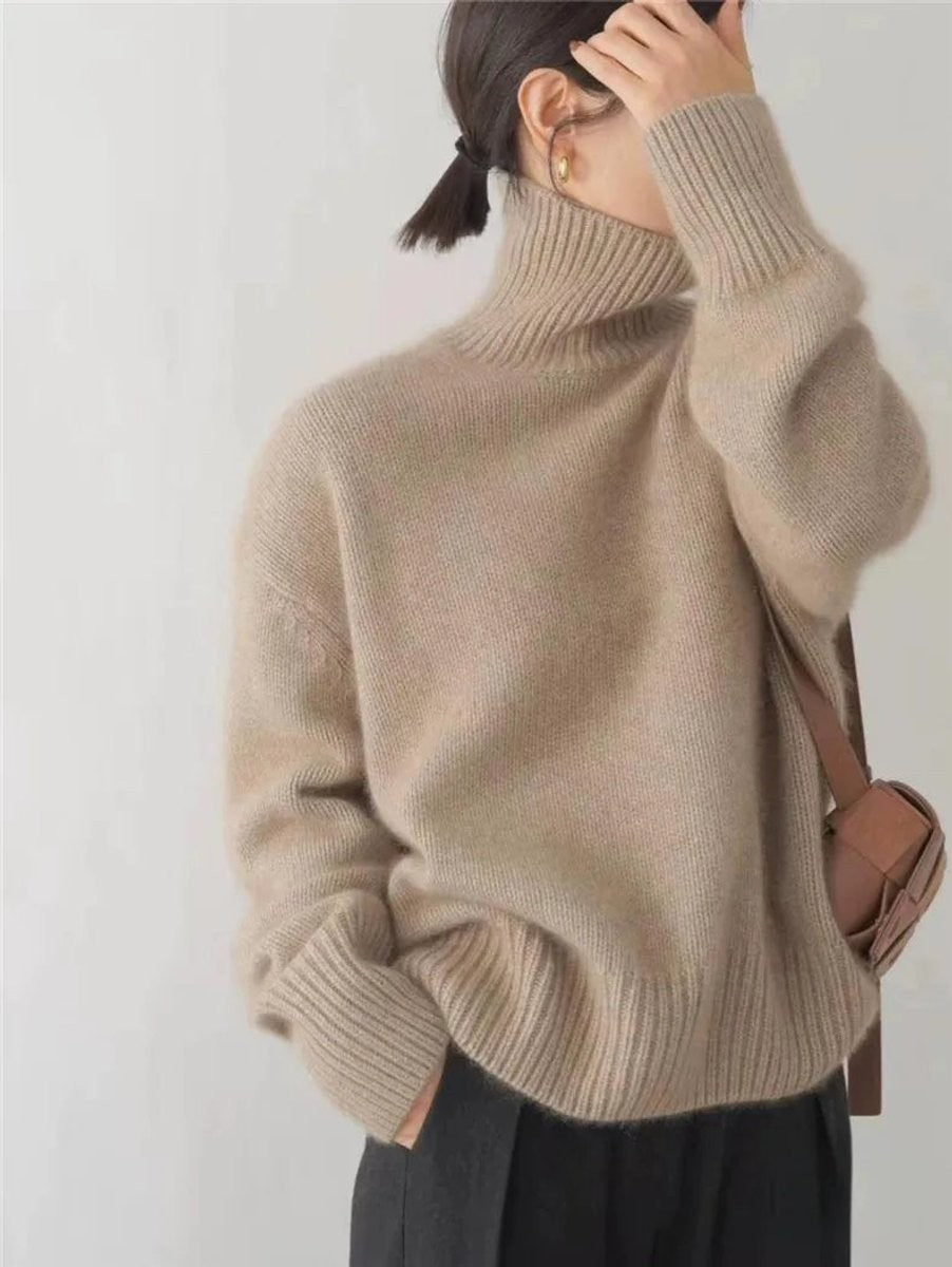 Camel chunky knit turtleneck sweater worn with a crossbody bag and black pants