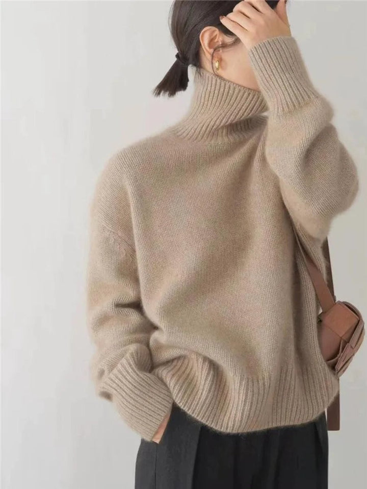 Camel chunky knit turtleneck sweater worn with a crossbody bag and black pants