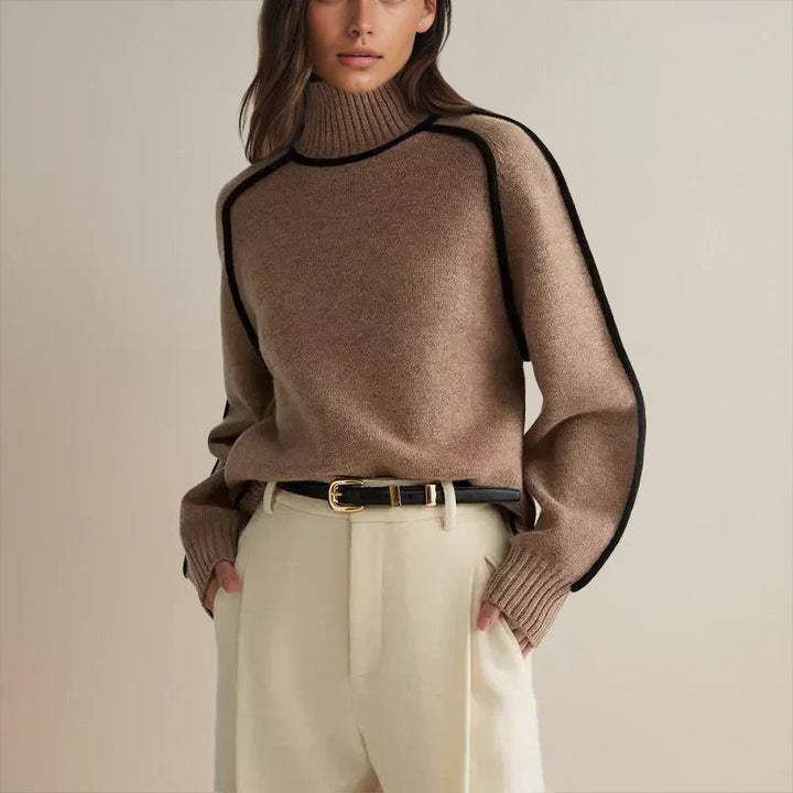 taupe oversized turtleneck sweater paired with belted cream trousers