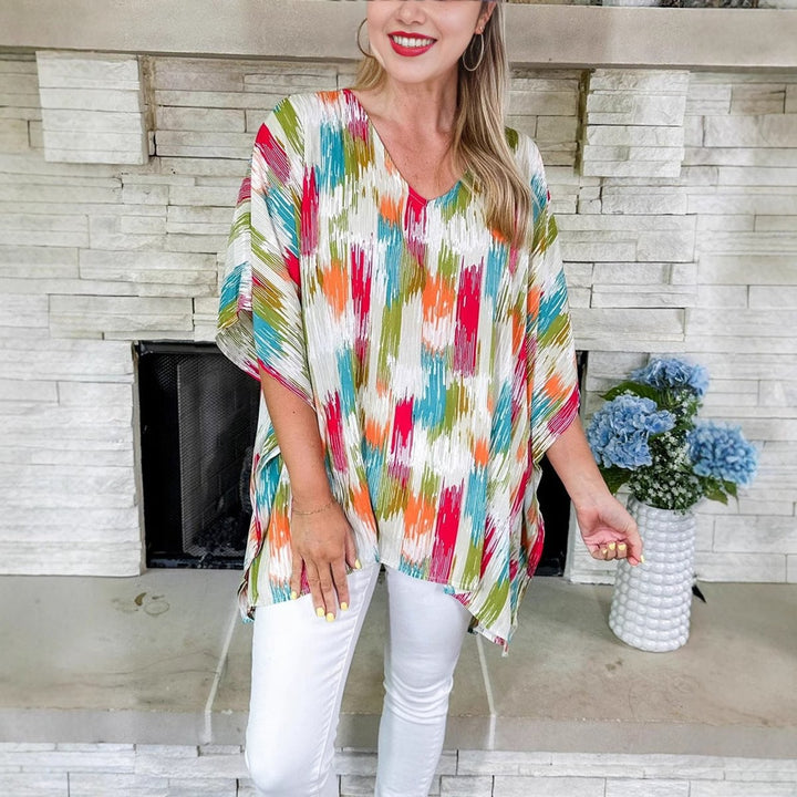 Oversized V-neck tunic top in multicolor abstract print with white jeans