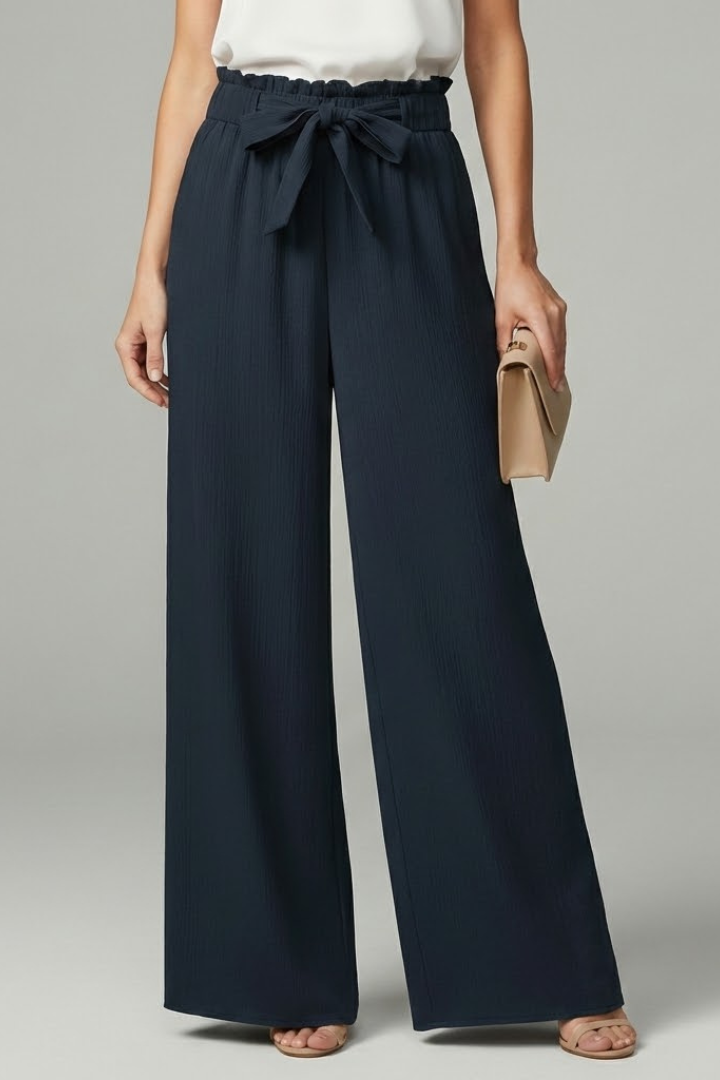 Model wearing navy wide-leg palazzo trousers with paperbag waist and tie belt