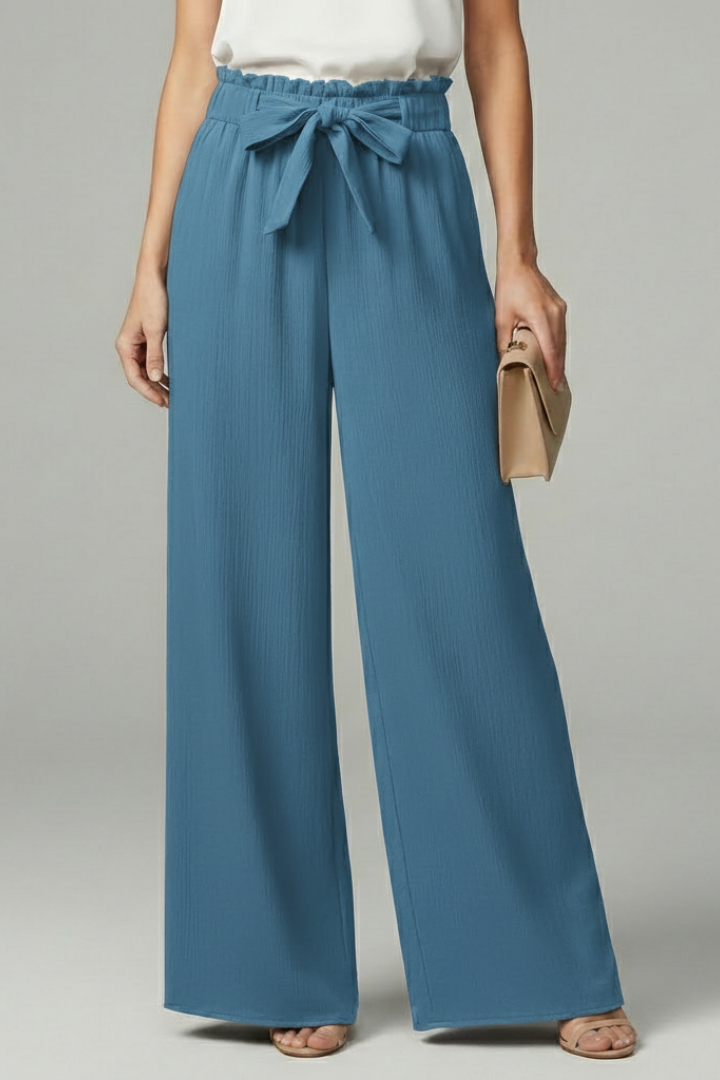 Model wearing teal blue wide-leg palazzo trousers with tie belt waist