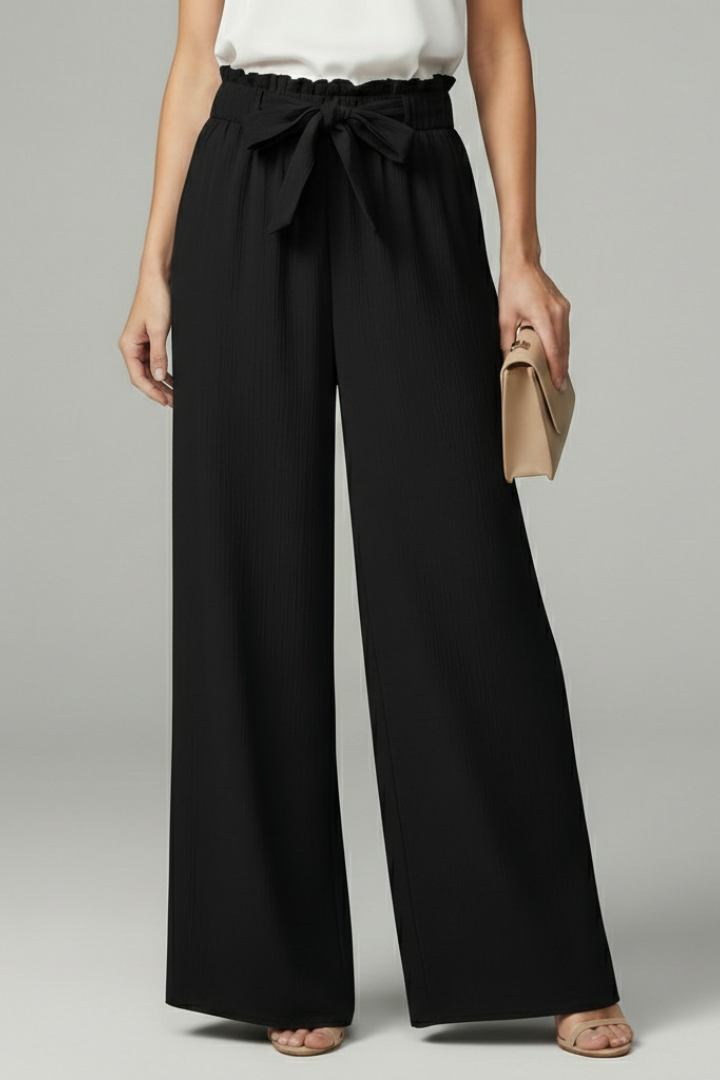 Model wearing black wide-leg palazzo trousers with tie belt and paperbag waist