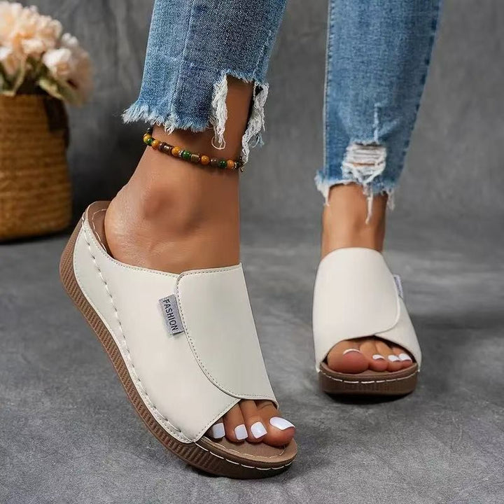 cream open-toe wedge sandal worn with ripped denim jeans