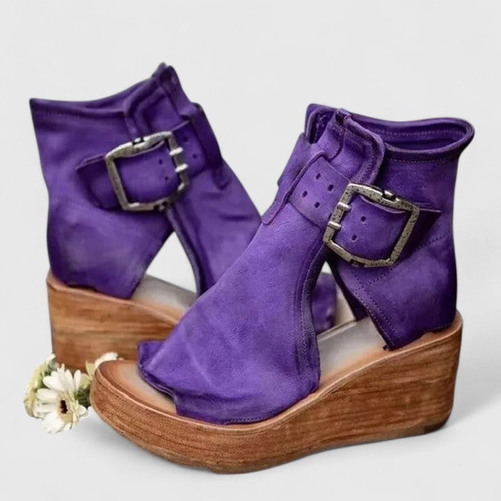 Purple leather cutout wedge booties with oversized buckle and chunky wooden heel
