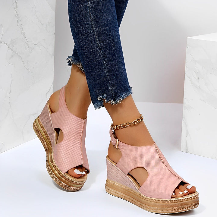 Pink peep-toe wedge sandals with cutout sides and ankle buckle closure