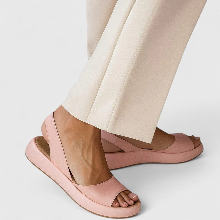 Blush pink slingback platform sandals worn with cream wide-leg trousers