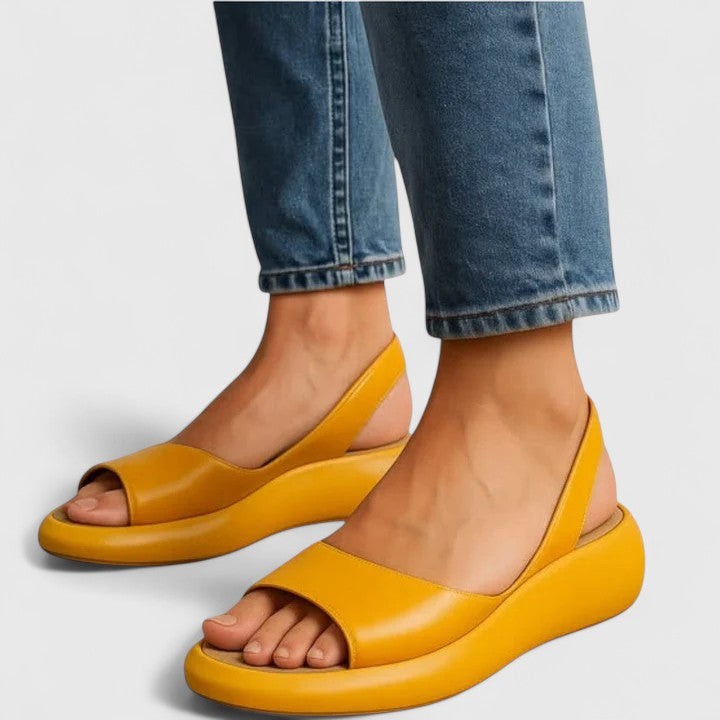 Mustard yellow open-toe wedge sandals paired with classic blue jeans