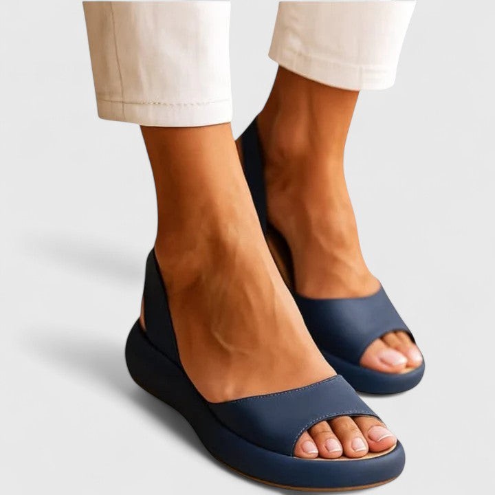 Navy blue open-toe wedge sandals paired with cream cropped trousers