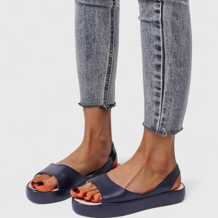 Navy leather slingback sandals with platform sole worn with gray jeans