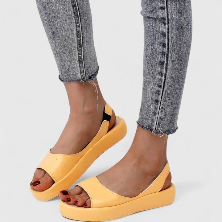 Mustard yellow platform sandals with slingback strap worn with denim
