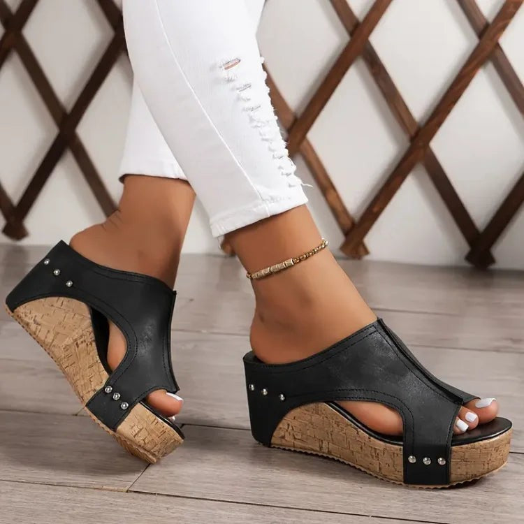 black cutout wedge sandal worn with cork platform heel