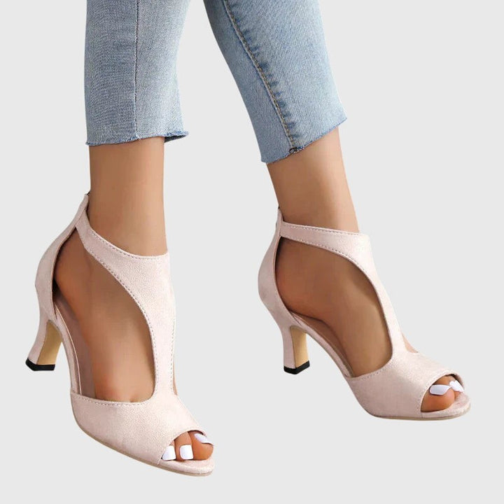 Side view of nude suede peep-toe sandals with curved cutout detail