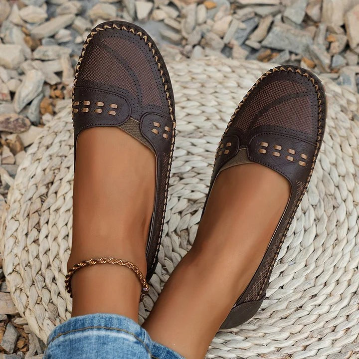 dark brown perforated loafers displayed together on woven straw mat