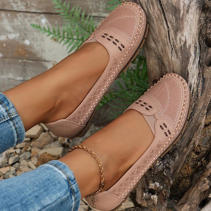 pink perforated flats resting against tree bark showing cutout design