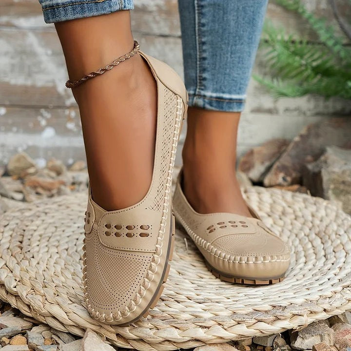 beige slip-on loafers worn on foot showing perforated toe design