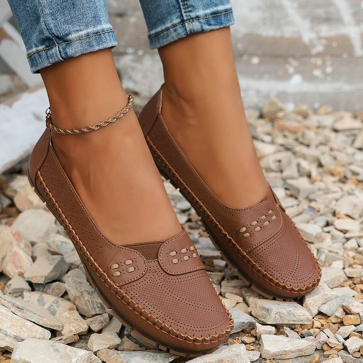 camel brown perforated flats worn with ankle bracelet and jeans