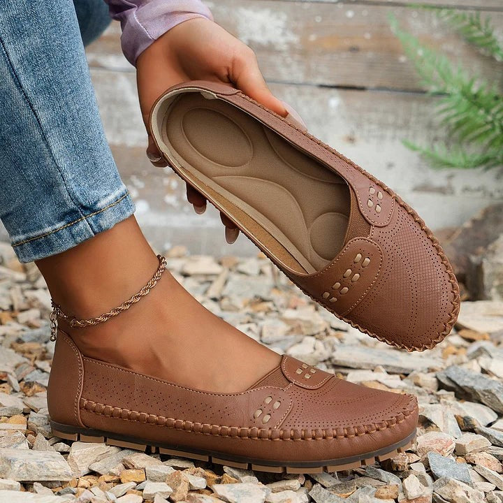 brown leather loafer with visible cushioned insole held by hand