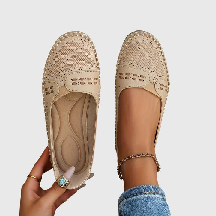 Beige leather slip-on flats with perforated toe and whipstitch trim