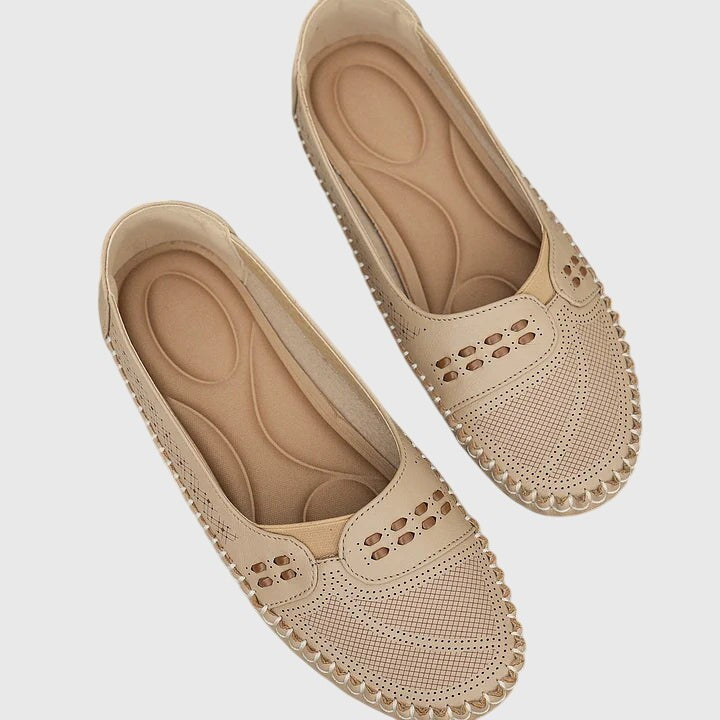 Beige perforated leather flats with cushioned insole, top view