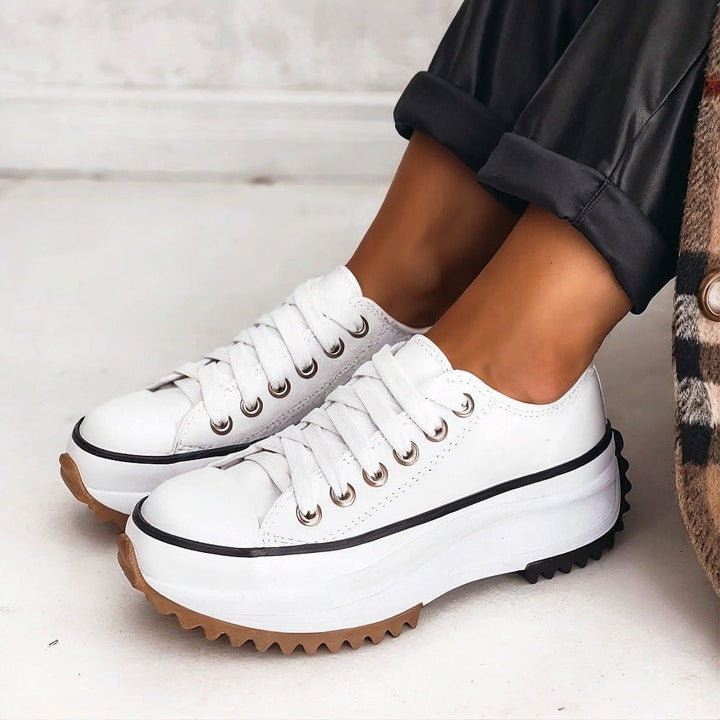 White leather platform sneakers with black trim and gum rubber outsole