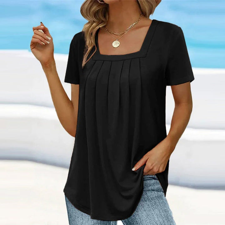 Black pleated tunic top with square neckline and curved hem