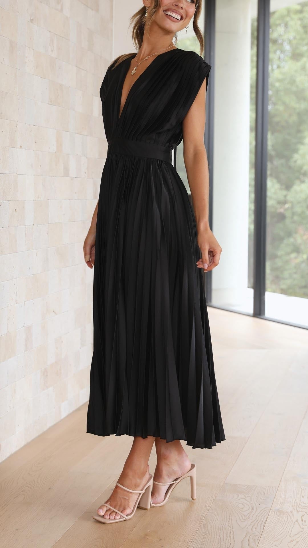 Back view of black pleated satin dress with open tie-back neckline