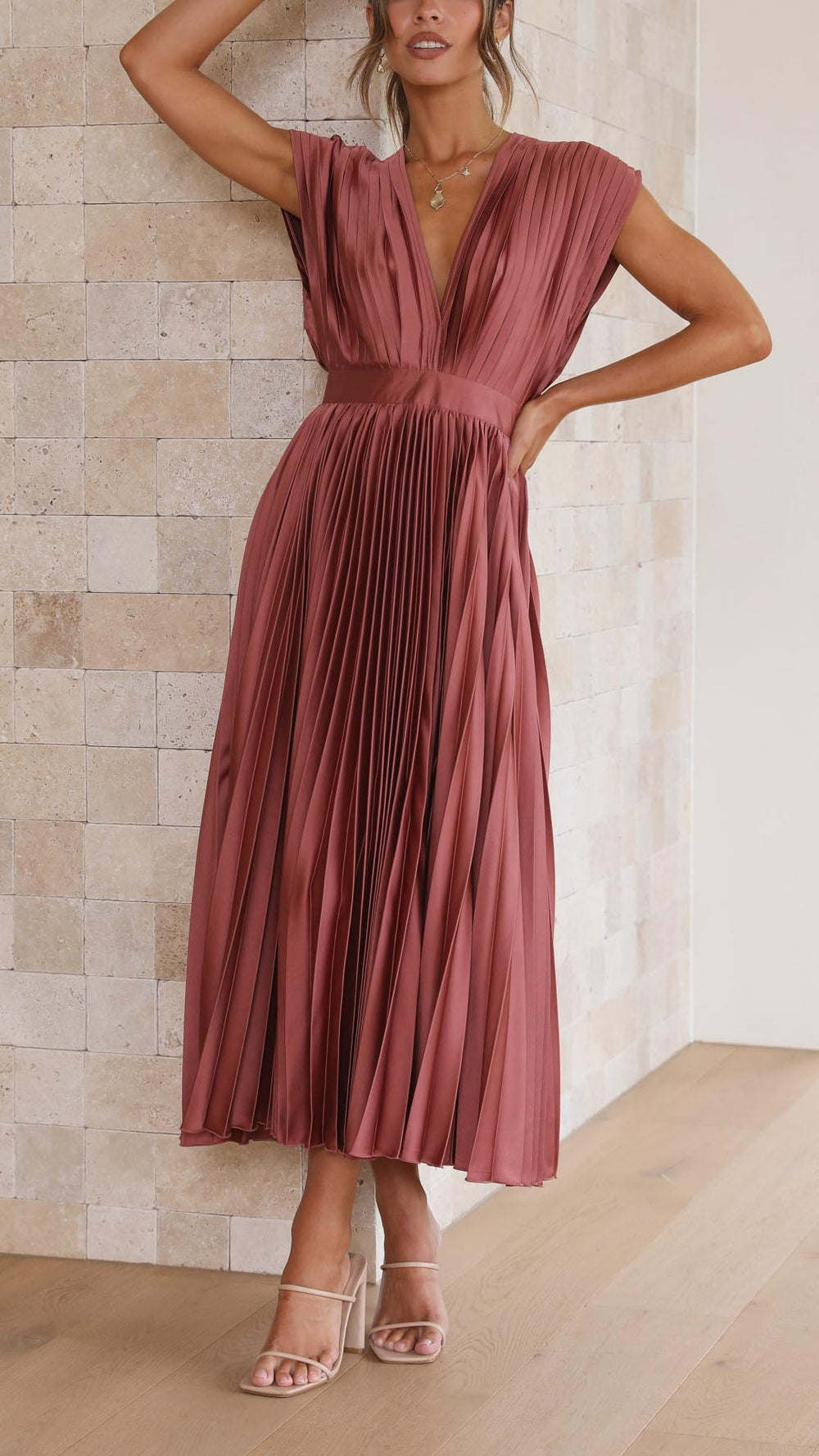 Rust pink pleated satin dress featuring cinched waist and flowy skirt