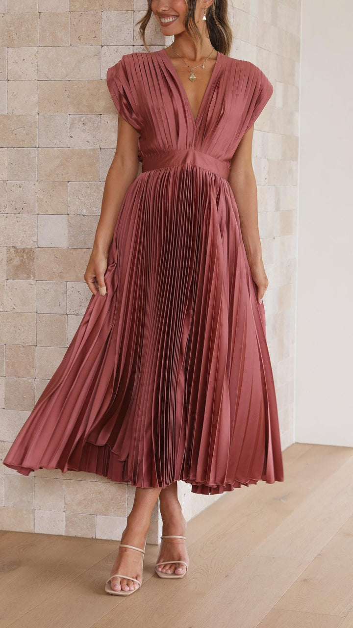 Model twirling in rust pink pleated satin midi dress with V-neckline