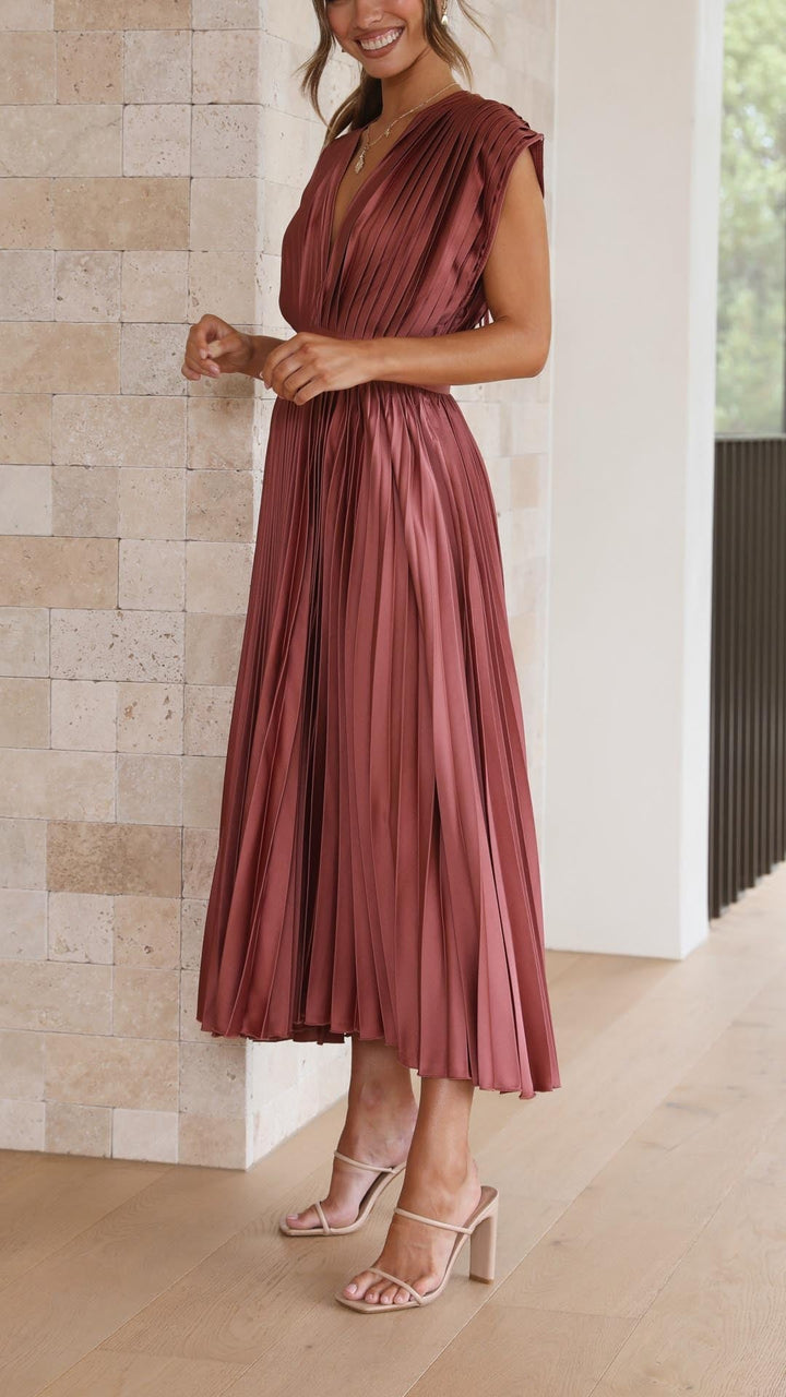 Side profile of rust pink pleated satin midi dress with cap sleeves