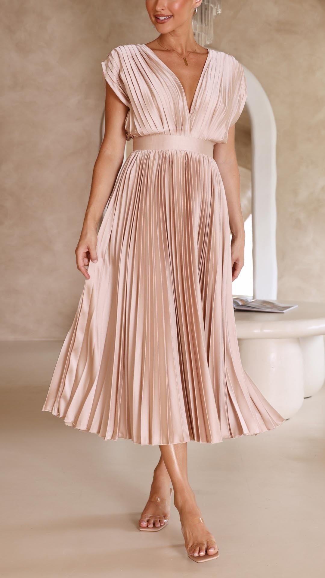 Blush pink pleated satin dress showing flowing accordion pleat skirt